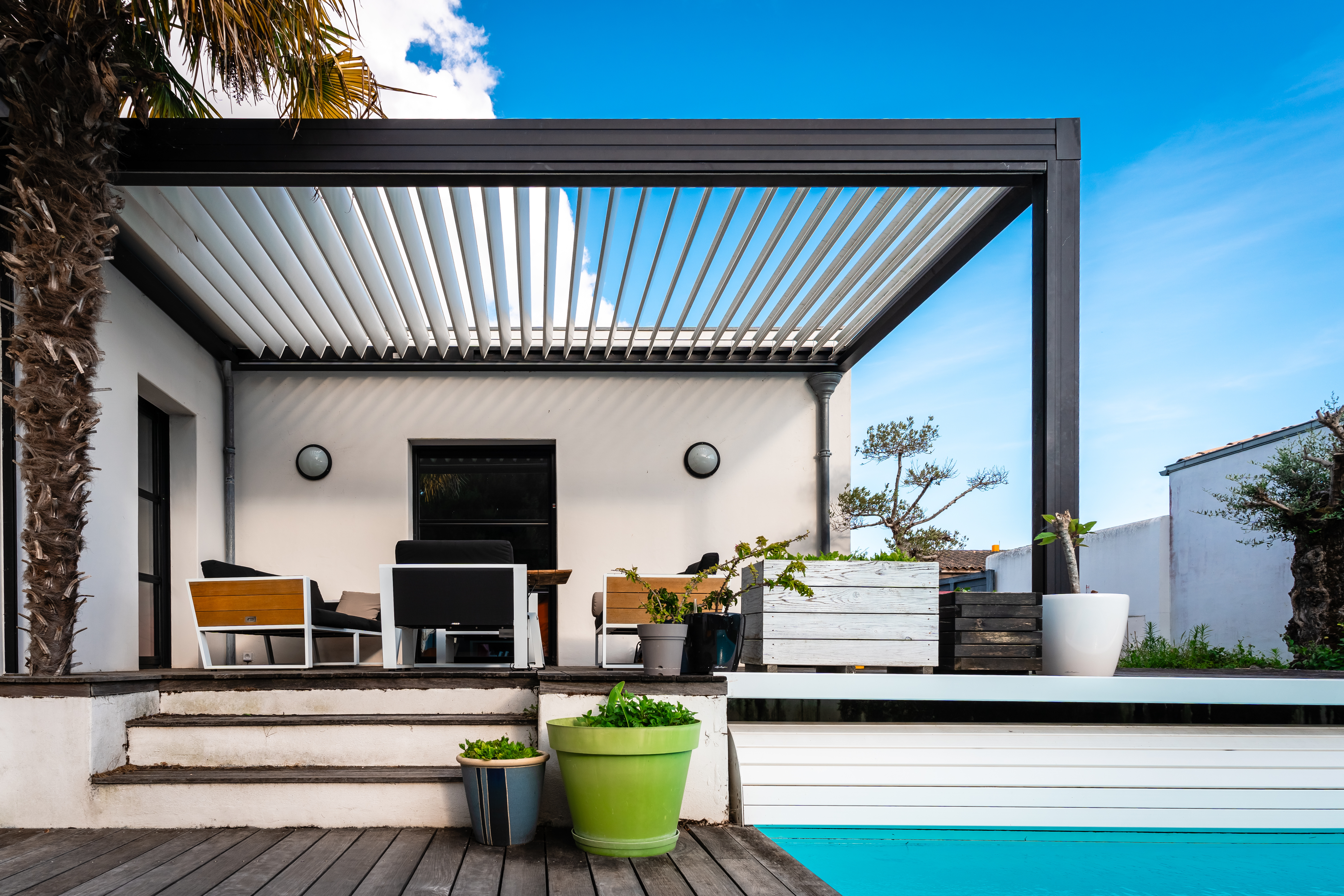 black modern pergola over patio next to pool.